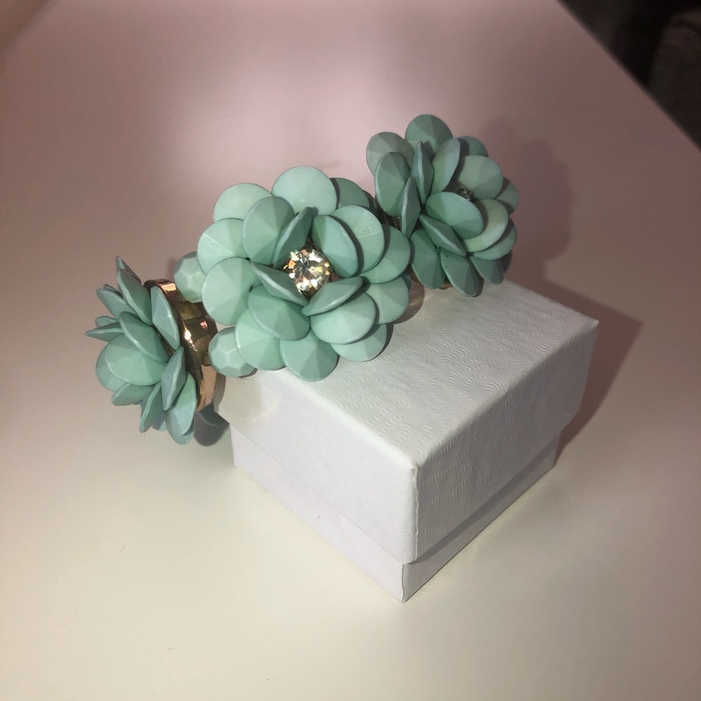 Green flower bracelet with white gem accents